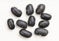 Several raw black turtle beans close up on gray