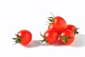 Several red cherry tomatoes with green leaves and one lying separately on a white background, isolate Royalty Free Stock Photo