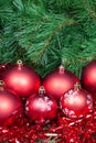 Several red Christmas baubles tinsel and Xmas tree Royalty Free Stock Photo