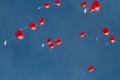 Several red heart-shaped balloons in flight, blue sky Royalty Free Stock Photo