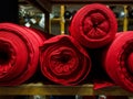 Several red rolls of knitted fabric. Woven factory or warehouse