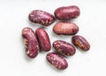 Several red spotted pinto beans close up on gray