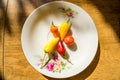 Several red and yellow chilies in a small plate on a wooden cutting board Royalty Free Stock Photo