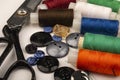 Several reels of multicolored sewing thread, multicolored buttons of different sizes, and large vintage sartorial scissors on a Royalty Free Stock Photo