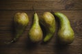 Several ripe pears lying on a wooden textural background