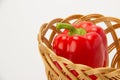 Several ripe sweet and hot peppers in a straw basket on a white Royalty Free Stock Photo