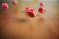 Several rolling red dice fall on a table