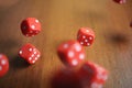 Several rolling red dice fall on a table