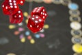 Several rolling red dice fall on a table with boardgame. Gameplay moments Royalty Free Stock Photo