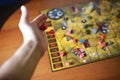 Several rolling red dice fall on a table with boardgame. Gameplay moments Royalty Free Stock Photo