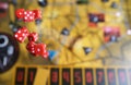 Several rolling red dice fall on a table with boardgame. Gameplay moments Royalty Free Stock Photo