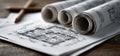 Several rolls of blueprints are resting on a wooden table surface Royalty Free Stock Photo