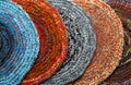 Several round, colored mats crocheted from thick threads