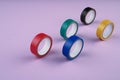 Several round rolls of colored plastic tape lie in a row