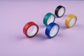 Several round rolls of colored plastic tape lie in a row