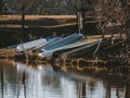 several row boats docked at the edge of a lake in a park Royalty Free Stock Photo