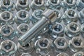 Several rows of hex nuts with round base and top threaded bolt.