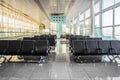 Several rows of modern black seats in the empty sunny waiting hall of the airport. Concept of loneliness, waiting, travelling, Royalty Free Stock Photo