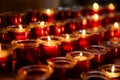 Several rows of burning votive candles in a dark European Catholic church in Rome Italy seeking favor from the Lord or Royalty Free Stock Photo