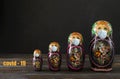 Several Russian matryoshka in a mask on a black background, protection from covid-19