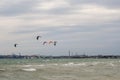 Several sails of kate surfers in the sea against the backdrop of a big city. Odessa. Ukraine. 2020.05.24