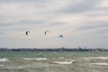Several sails of kate surfers in the sea against the backdrop of a big city. Odessa. Ukraine. 2020.05.24