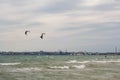 Several sails of kate surfers in the sea against the backdrop of a big city. Odessa. Ukraine. 2020.05.24