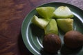 Sapodilla fruit and melon are placed in a green plastic plate. Royalty Free Stock Photo