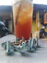 several screws lying on the table along with sweet iced tea Royalty Free Stock Photo