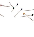 Several sewing pins with colored beads lie on a white isolated background. Place for text. View from above