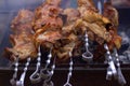Several skewers with pork entrecotes lie on a steaming grill