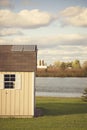 Several solar panels on the roof of small outbuilding.