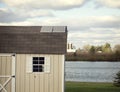 Several solar panels on the roof of small outbuilding.