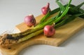 Several stems of onion plants and several whole red onions Royalty Free Stock Photo