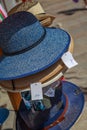 several straw hat stacked in front of a merchant shop