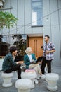 several students chatting using laptops in front of the building Royalty Free Stock Photo