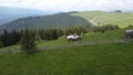 Several SUVs are driving along a mountain road along a dirt road. Aerial view.