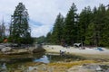 Several tents people load kayak on shell beach in tiny bay on island leisure activities