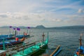 Several traditional Filipino Outrigger boats or `banca` moored at a wooden pier on the shore of Taal Lake, Tagaytay Philippines.