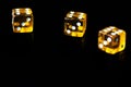 Several transparent yellow dice on a black surface closeup. Gambling ÃÂoncept background