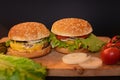 Several two homemade cheeseburgers on a wooden Board