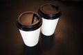 Several, two paper white cups with a plastic black lid for takeaway coffee on a black background Royalty Free Stock Photo