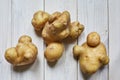 Several ugly potatoes on a wooden background. The concept of store rejection of ugly food. Non-GMO Organic.