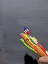 several used toothbrushes of various colors on a black background