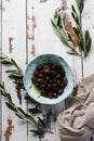 Several Varieties Of Fresh Olives In Different Ceramic Plates On An Old Vintage Gray Napkin Tablecloth Table Background. Natural P