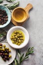Several Varieties Of Fresh Olives In Different Ceramic Plates On An Old Vintage Gray Table Concrete Background. Natural Product