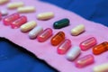 several variously-colored contraceptive capsules on a contrasting canvas