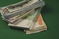 several wads of cash lying on top of each other on a green background
