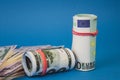 several wads of money of different currencies on a blue background Royalty Free Stock Photo