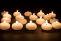 Several white candles at a black background